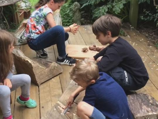 Children working on a wooden sculpture