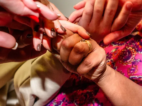 Women's hands held together in a circle