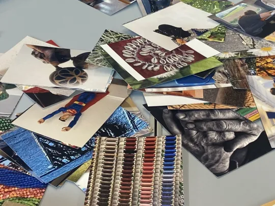 Older person sat at a table with photographs and books