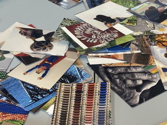 Older person sat at a table with photographs and books