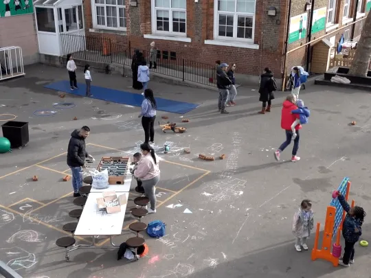 Children and parents playing together at Surrey Square Primary School playground