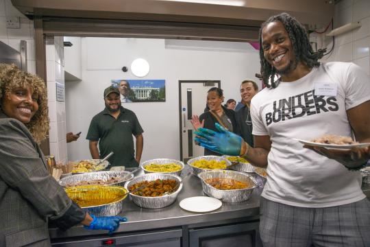 Photo of people enjoying food in a kitchen