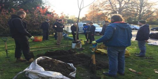 Dulwich Park environment with people digging to plant a tree