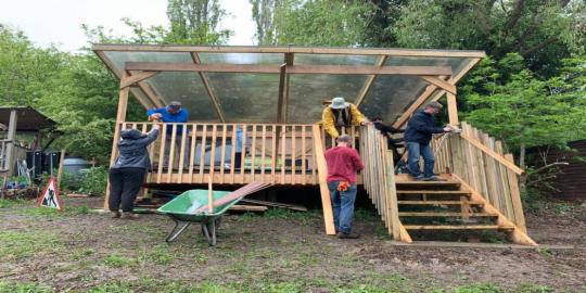 Allotment of refuge infrastructure environment people working on an outdoor building structure