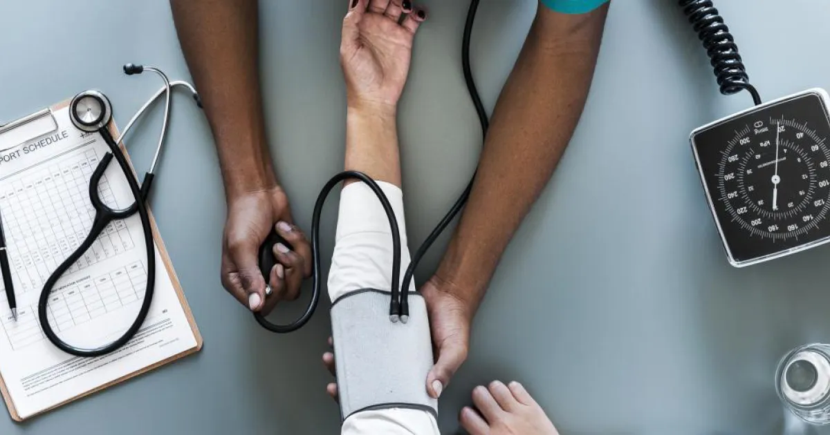 A doctor checking a patients pulse using a stethoscope.