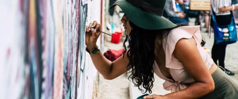 Young woman painting on wall