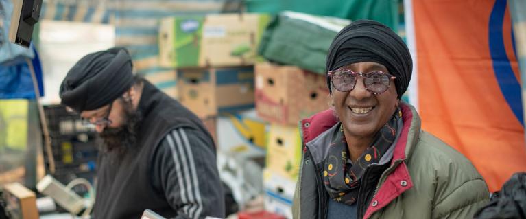 Market stall owner smiling at the camera