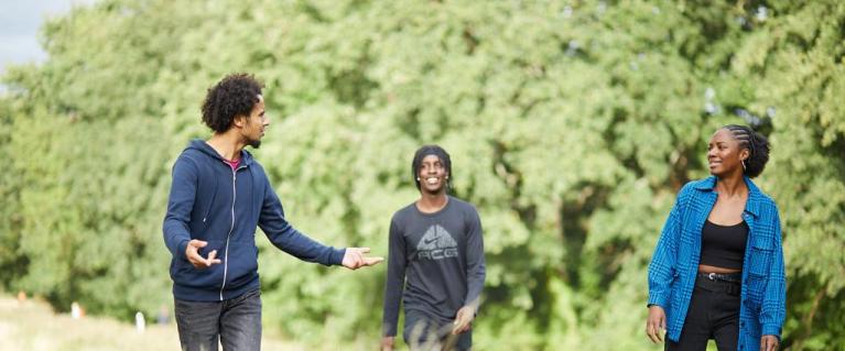 Three young people walking in a park