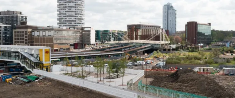 wide view of a train station city buildings behand and surrounding area