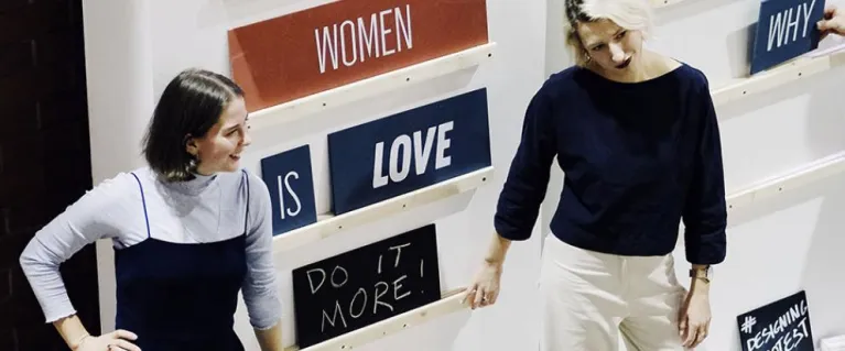 Two women presenting exhibition
