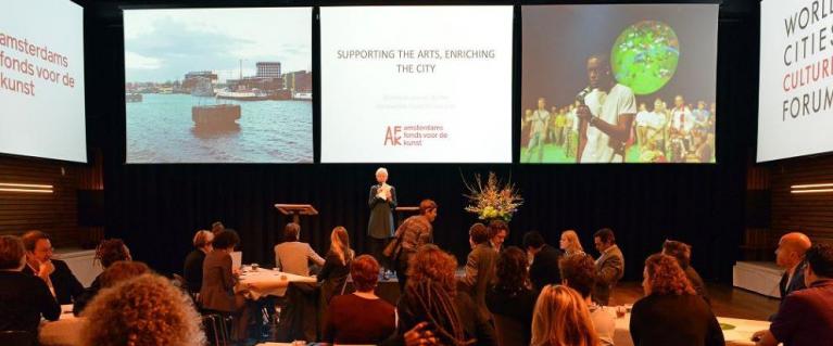 World Cities Cultural Forum audience with speaker talking about supporting the arts, enriching the city