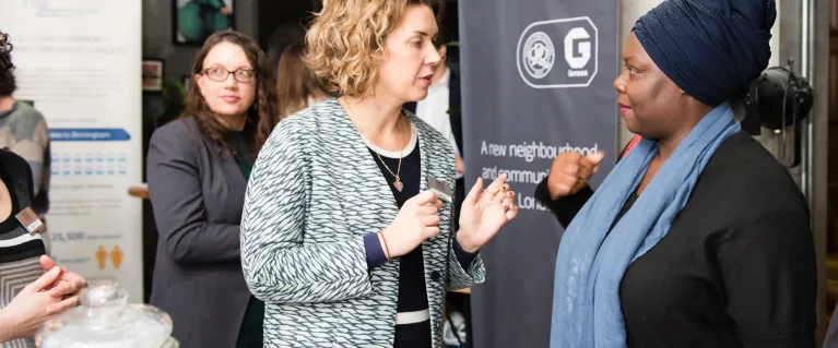 Two people talking at community event