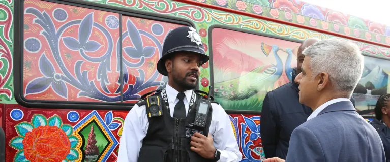 The Mayor speaking with a police officer during a community outreach visit