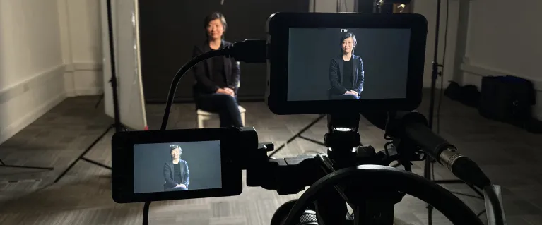 A person being filmed by a video camera in a studio