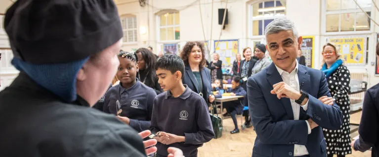 Mayor of London, Sadiq Khan, in a school canteen with canteen staff and students.