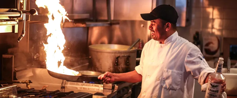 a restaurant chef using a frying pan in a kitchen