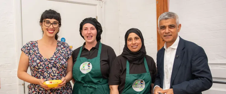 Three women servings school meals standing with Mayor Sadiq Khan