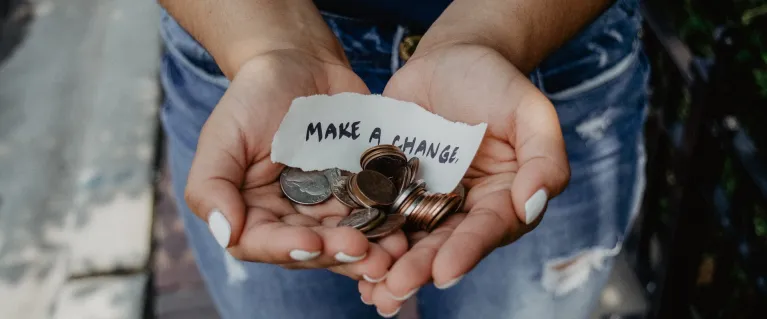 Hands offering coins and note that says 'make a change'