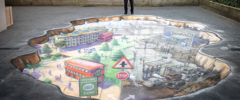 Sadiq Khan standing next to drawing on pavement about climate change