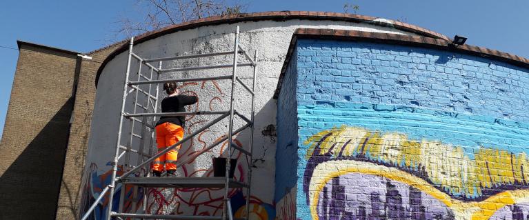 A mural in London being painted by a female artist 