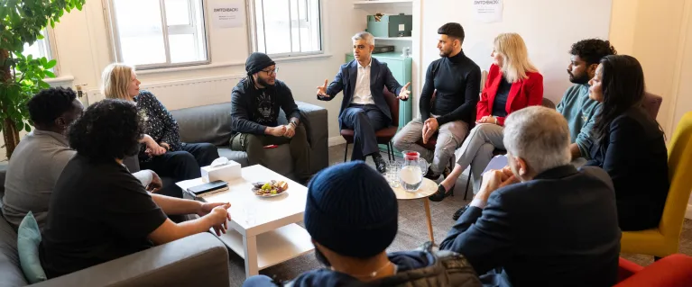 The mayor with community members talking in a circle.