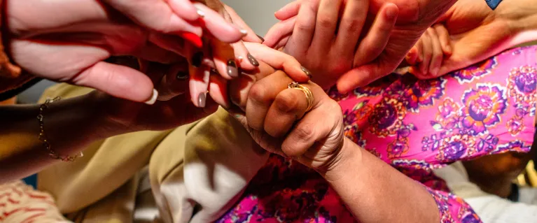 Women's hands held together in a circle