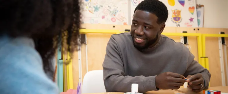 smiling man sitting at school table