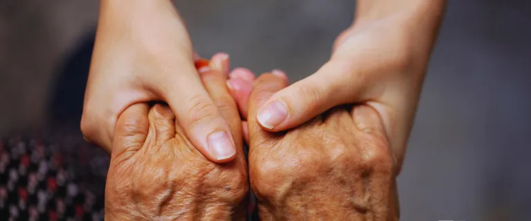 An older person and a young person holding hands with the IFB Gaming logo in the corner