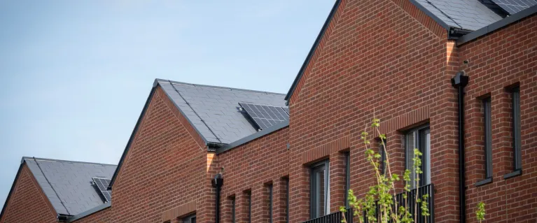 Red brick social housing with a blue sky in the background.