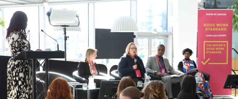 People on a stage on a panel with audience members