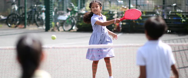 Children outside playing tennis