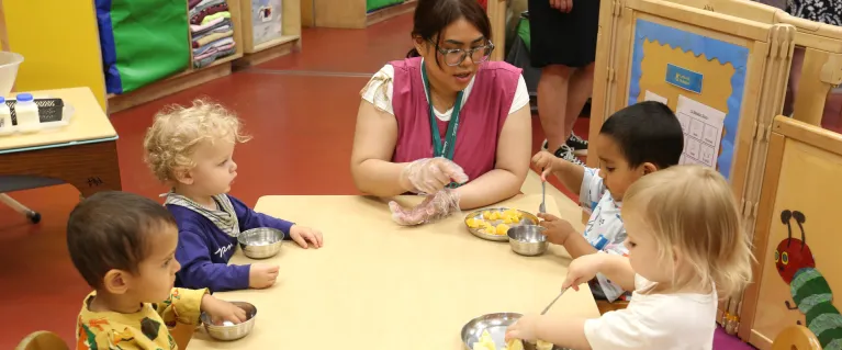 Young children learning about healthy eating from early years staff