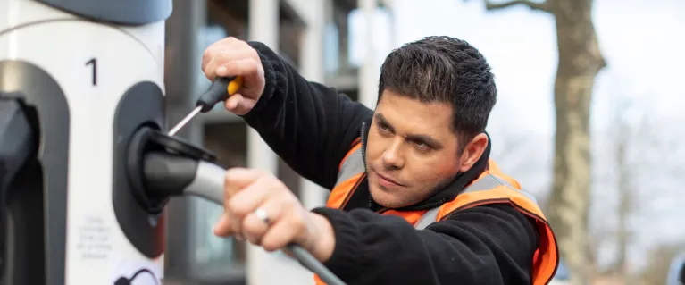 Man in a wheelchair fixing a car