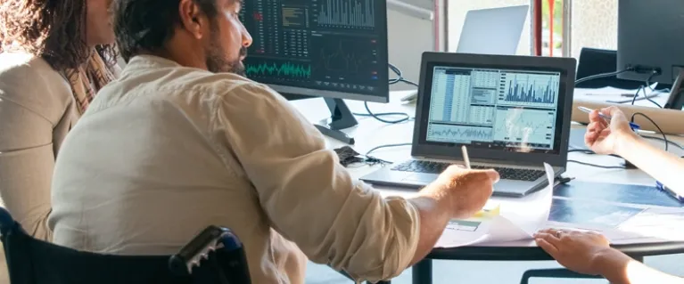 Diverse workforce colleagues discussing information on a laptop