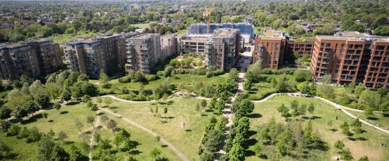 Housing development, green space in front and homes at the back