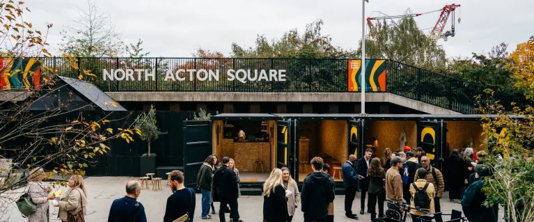Autumnal image of North Acton Square, featuring shipping containers