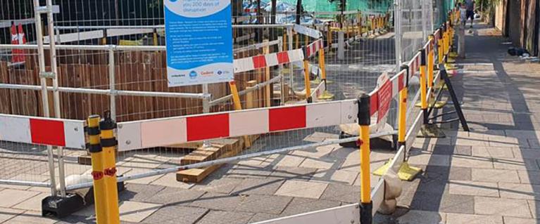 Road work confined by metallic fencing on a London road