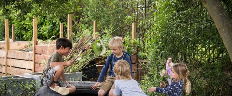 Children on a tire in a garden