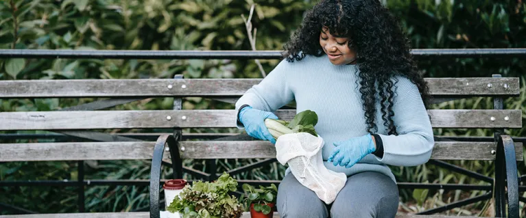 Volunteer organises plants on a bench
