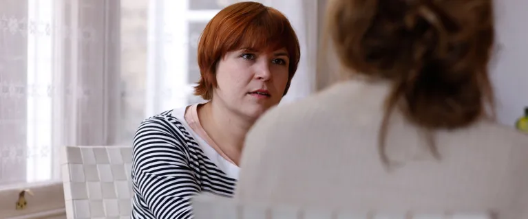 Two women sat in chairs having a conversation