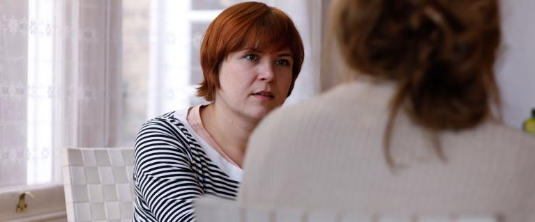 Two women sat in chairs having a conversation