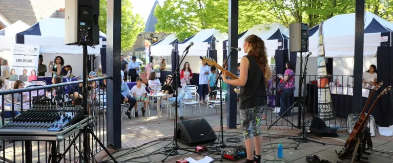 An artist performing at an event as members of public watch