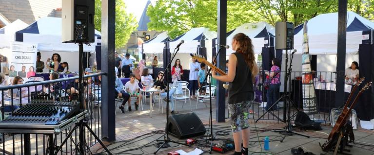 An artist performing at an event as members of public watch