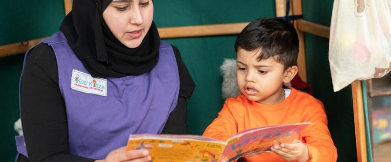 Child reading with teacher