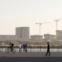 People walking and cycling by the docks in the context of emerging new development in the Royal Docks
