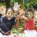 Two children wearing animal face painting