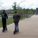Two people riding e-scooters