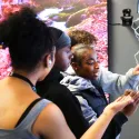 Young people writing on a digital whiteboard