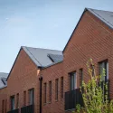 Red brick social housing with a blue sky in the background.