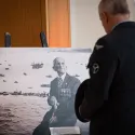 Man looking at a portrait of British veteran